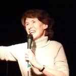 Jane Condon on stage holding a microphone