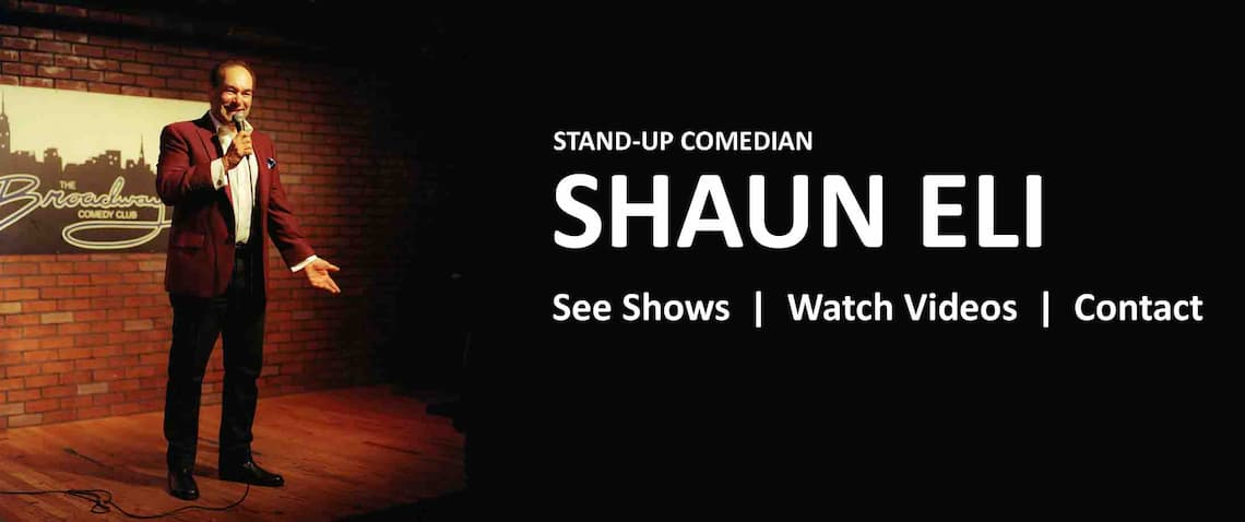 Corporate Comedian Shaun Eli in red sports jacket and white dress shirt, on stage at Broadway Comedy Club. With clickable links to the Shows, Videos and Contact pages (which you can also access from the menu at the top of the page).